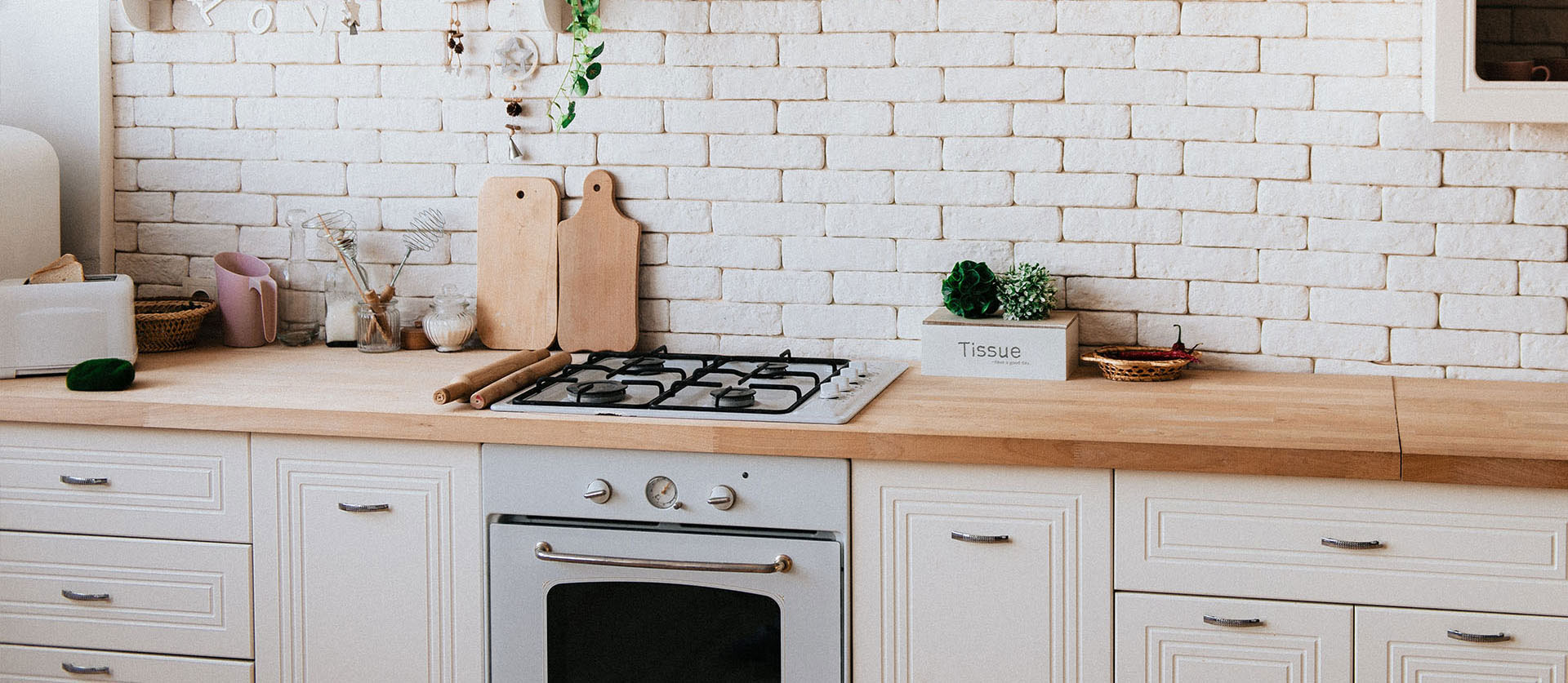 Eine saubere, weiße Küchenzeile im shabby-hygge-Look  mit heller Küchenplatte aus Holz - pexels---Dmitry Zvolskiy